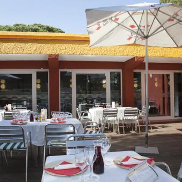 Tables on the terrace of the restaurants with sun umbrellas